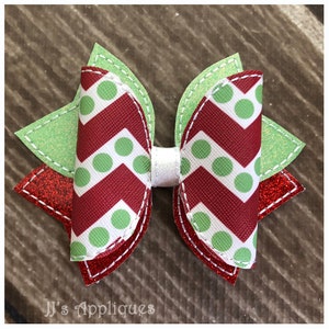 Peut inclure: Un nœud en chevron rouge et vert avec des pois blancs. Le nœud est composé de deux couches de tissu, l'une en paillettes vertes et l'autre en paillettes rouges.