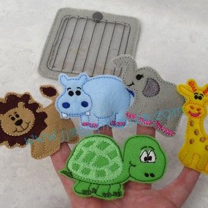 May include: Set of five felt finger puppets featuring a lion, hippopotamus, elephant, giraffe, and turtle. The puppets are brown, blue, grey, yellow, and green. The puppets are designed to fit on fingers and are perfect for imaginative play.