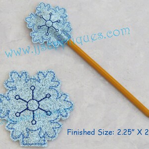 May include: A blue snowflake pencil topper with a yellow pencil. The topper is 2.25 inches by 2.25 inches.