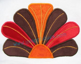 May include: A colorful embroidered design featuring a fan-shaped arrangement of brown, orange, and red fabric petals. The petals are outlined in gold thread, creating a decorative and festive look.