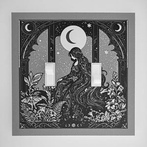 May include: A double light switch cover plate featuring a black and white illustration of a figure with long flowing hair sitting amidst plants and flowers under a crescent moon and starry sky, framed by an arched structure with two white toggles.