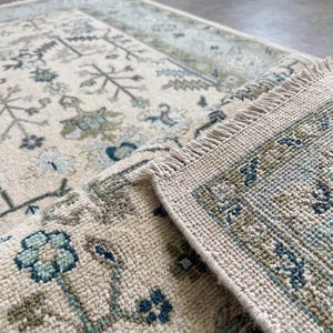 Close-up of the clean white fringes and traditional finish of this room size rug inspired piece.