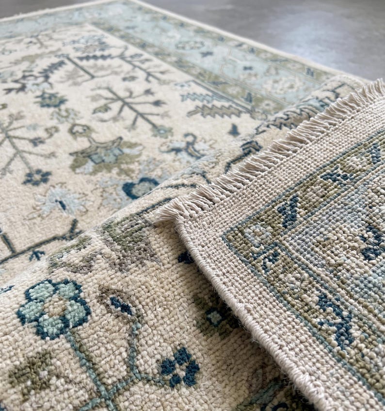 Close-up of the clean white fringes and traditional finish of this room size rug inspired piece.