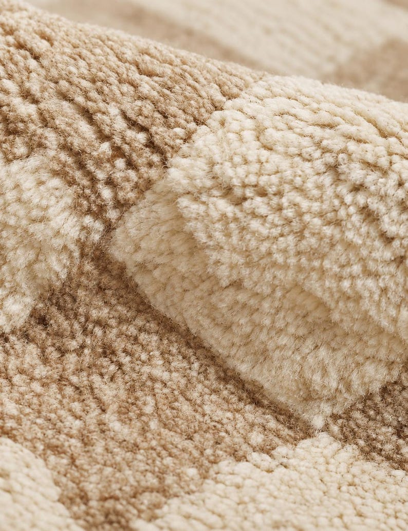 Close-up texture shot of the checkered area rug highlighting the plush textured wool fibers and luxury Tapis en laine quality.