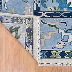 Extreme macro of the hand knotted wool fibers showing the high-density weave and soft white wool texture.