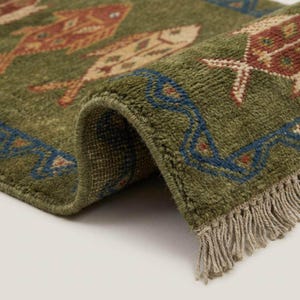 Close-up of the rust red and terracotta tribal fish motifs, offering a sophisticated vibe compared to a loud funky rug or novelty fun rugs.