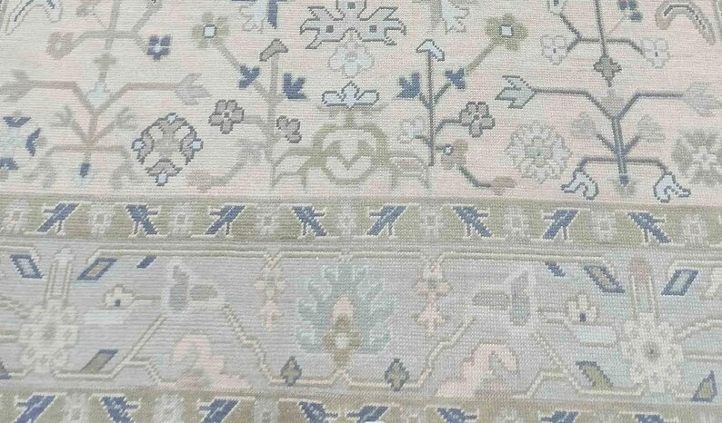 Detailed view of the navy blue floral accents and warm taupe vine patterns on this stunning ivory rug.