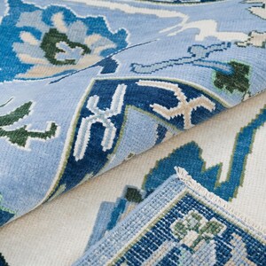A modern sofa leg resting on the 9x12 area rug, demonstrating the rug's durability and size.