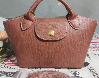 Longchamp caramel-brown mini leather handbag is compact and portable—the perfect gift for that special lady.