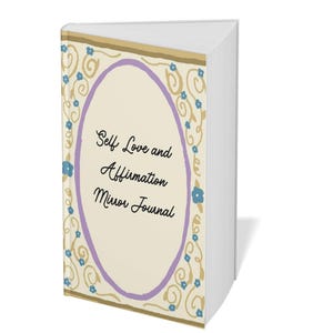 May include: A journal titled "Self Love and Affirmation Mirror Journal." The cover features an oval design with a light beige background, a lavender border, and floral accents in blue and gold. The journal's pages are white.