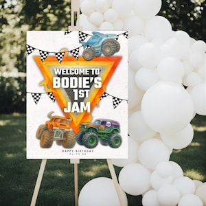 May include: A rectangular welcome sign featuring a central orange triangle with the text "WELCOME TO BODIE'S 1ST JAM" and "HAPPY BIRTHDAY 04.15.XX". The design includes black and white checkered bunting, a shark monster truck, and two other trucks.