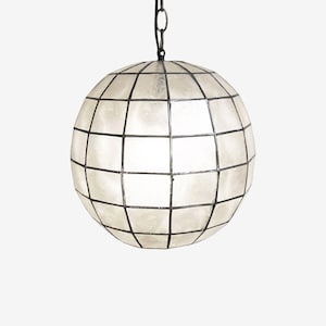 May include: A spherical pendant light with a grid pattern. The light fixture is white with black lines, and hangs from a black chain. The globe-shaped lamp is a decorative lighting element.