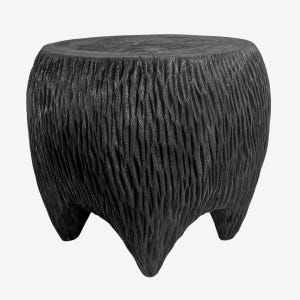 May include: A black, hand-carved wooden stool with a textured, bark-like surface. The stool has a round top and three sturdy, pointed legs. The dark color and natural texture give it a rustic, yet modern aesthetic. This unique piece is suitable for indoor or outdoor use.