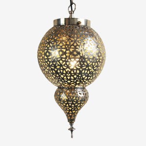 May include: A decorative, hanging pendant light with a pierced metal shade. The light fixture has a spherical top and a teardrop-shaped bottom, both with intricate cut-out patterns. The metal has a warm, antique finish, and the light glows from within.