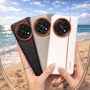 May include: Three phone cases in black, gray, and white, each featuring a circular camera module with four lenses and an orange accent ring. The cases are held up against a beach backdrop.