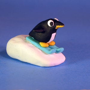 Happy Penguin skiing down slope figure