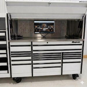 Könnte beinhalten: Ein weißer Werkzeugwagen aus Metall mit einem großen, geöffneten Deckel, mehreren horizontalen Schubladen mit schwarzen Griffen und einer Arbeitsfläche aus Edelstahl. Ein Computermonitor zeigt den Text Maligator Fab.