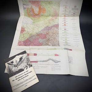 May include: A 1946 booklet titled The Geology of the Mt. Washington Quadrangle New Hampshire with a black and white cover illustration, accompanied by a large, unfolded, multi-colored geological survey map featuring detailed terrain and legends.