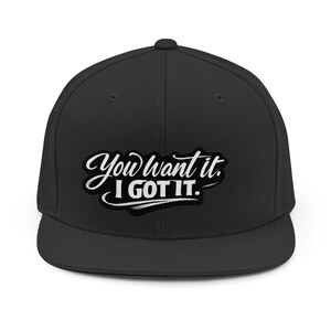 May include: A black baseball cap with a flat brim. The cap features the text "You want it. I got it." in white script with a black outline. The hat is a classic, casual accessory.