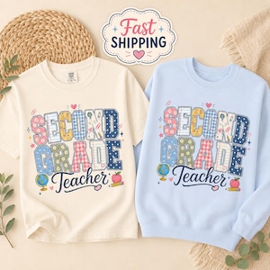 May include: A cream-colored t-shirt and a light blue sweatshirt, both featuring the text "SECOND GRADE Teacher" in a multi-patterned block font. The designs include small illustrations of a globe, a pencil, and an apple in various colors.
