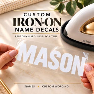 Puede incluir: Una hoja adhesiva transparente con las letras mayúsculas blancas MASON, situada bajo el texto CUSTOM IRON-ON NAME DECALS, PERSONALISED JUST FOR YOU, y NAMES CUSTOM WORDING, con una prensa térmica blanca y dorada al fondo.