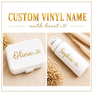 May include: A white rectangular lunch box and a white cylindrical water bottle, both featuring custom gold vinyl lettering. The lunch box displays the name Olivia, and the water bottle displays the name Sophia, each ending with a small heart graphic.