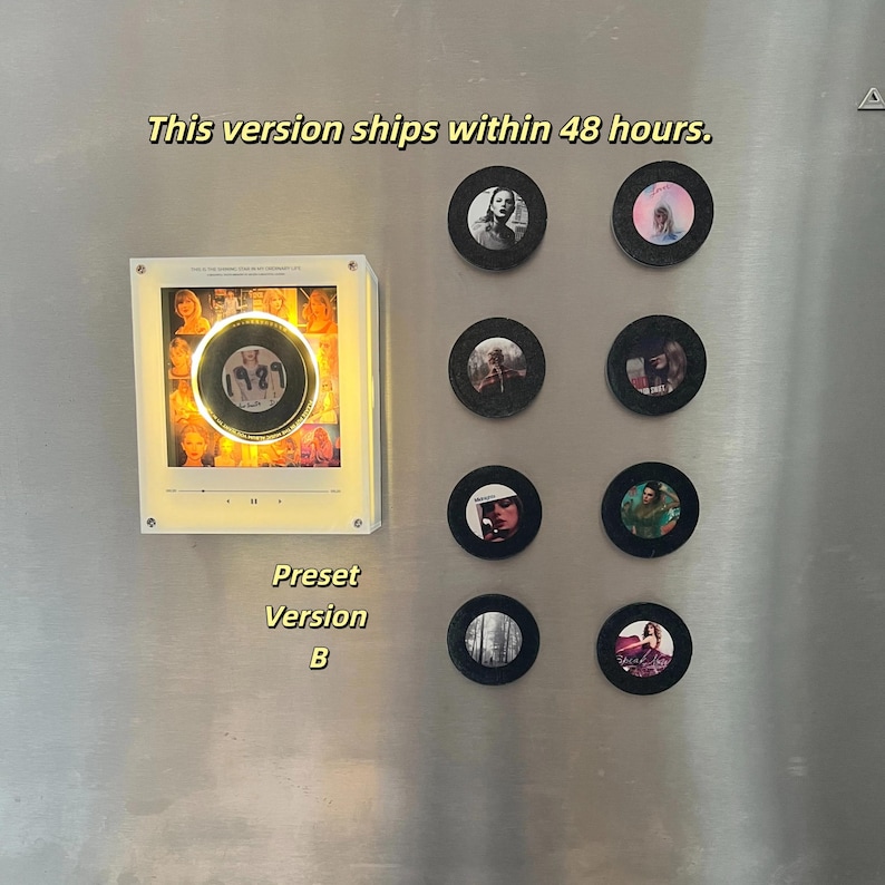 May include: A white square light-up display box featuring a central circular graphic with the text 1989, surrounded by a collage of images. Eight black circular magnets with various small photographic prints are arranged to the right side.