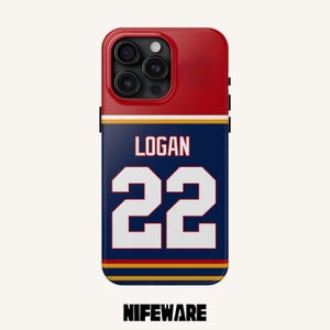 K&ouml;nnte beinhalten: Rote, marineblaue, wei&szlig;e und goldfarbene Handyh&uuml;lle. Auf der H&uuml;lle stehen der Name "LOGAN" und die Nummer "22" in Wei&szlig;. Der Markenname "NIFEWARE" ist unten aufgedruckt. Das Design ist gestreift.
