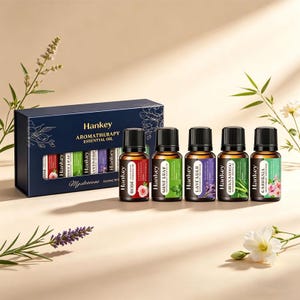 May include: Aromatherapy essential oil set by Hankey. The set includes a navy blue box with the Hankey logo and the words "Aromatherapy Essential Oil". Five small glass bottles are displayed, each with a different essential oil and label.