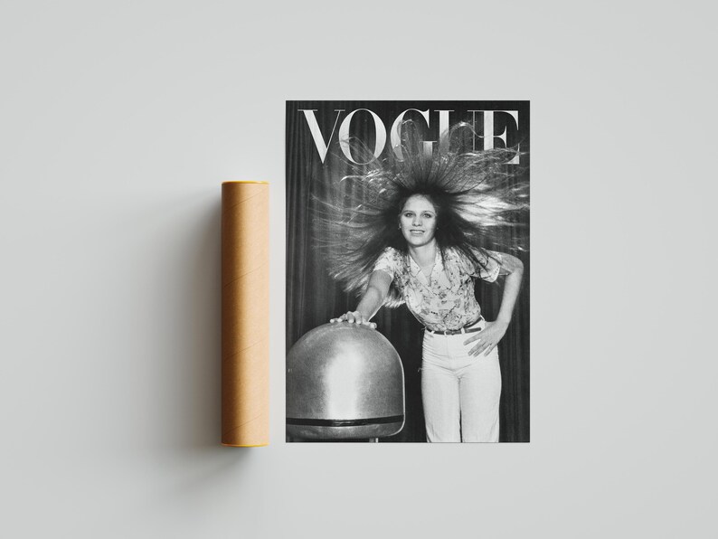 Puede incluir: Una portada de revista Vogue en blanco y negro con una mujer con el pelo peinado hacia arriba. La revista est&aacute; junto a un tubo de p&oacute;ster cil&iacute;ndrico marr&oacute;n. El logotipo de Vogue est&aacute; en la parte superior de la revista.
