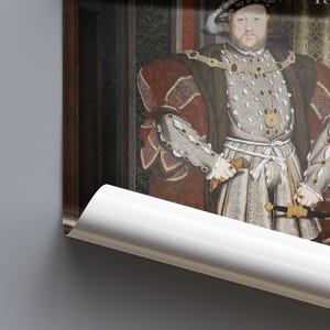 May include: A framed portrait of a man in regal attire, featuring a fur-trimmed robe, ornate jewelry, and a hat. The portrait is a historical artwork, with a dark background and a glimpse of a decorative curtain.