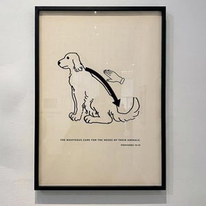 Könnte beinhalten: Ein gerahmter Kunstdruck mit einer schwarzen Strichzeichnung eines Hundes, der am Rücken gestreichelt wird. Unter der Illustration steht der Text: THE RIGHTEOUS CARE FOR THE NEEDS OF THEIR ANIMALS. PROVERBS 12:10. Der Druck ist in einem dünnen schwarzen Rahmen.