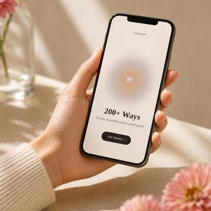 May include: A smartphone displaying a light-colored screen with the text Liebesstark, 200+ Ways, To love yourself and feel good again, and a Get Started button. The screen features a central soft-focus gradient circle with a small icon.