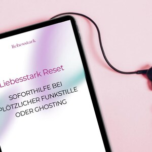 Może przedstawiać: Tablet z tekstem "Liebesstark Reset" i dodatkowym niemieckim tekstem na różowym tle. Czarne słuchawki są podłączone do tabletu. Obraz ma miękkie oświetlenie.