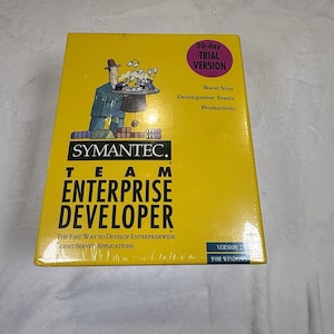 Può includere: Una scatola software rettangolare gialla per Symantec Team Enterprise Developer Version 2.0 per Windows. La parte anteriore presenta un'illustrazione a cartone animato di una persona in abito che tiene un vassoio con fogli, con il testo 30-day trial version.