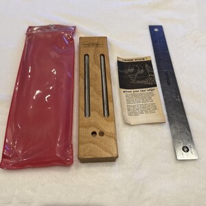 May include: A wooden Crock Stick knife sharpener with two metal rods, a red plastic sleeve, a metal ruler, and a paper instruction sheet. The instruction sheet reads "Crock Stick" and "Gives you the edge."