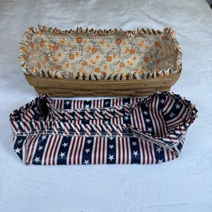 May include: A rectangular woven wooden basket with a removable fabric liner featuring a Halloween pattern of pumpkins and candy corn, paired with a separate fabric liner featuring a red, white, and blue star and stripe pattern with ruffled edges.