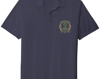 Puede incluir: Un polo de manga corta en color azul marino oscuro con cuello y tapeta de tres botones. En el pecho izquierdo lleva un emblema bordado con una corona de laurel dorada, dos palos de golf cruzados y el texto Bogey and Birdie con el número 2.