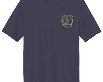 Puede incluir: Una camiseta de manga corta azul marino oscuro con un pequeño escudo bordado en el pecho izquierdo. El escudo muestra un número dos verde dentro de una corona de laurel dorada con el texto "BOGEYS" arriba y "BIRDIE" debajo del número.