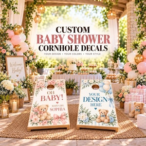 May include: Two custom cornhole board decals featuring teddy bears, floral arrangements, and text. One decal displays 'OH BABY! BABY GIRL SOPHIA' with pink flowers and a bow. The other shows 'YOUR DESIGN HERE' with blue flowers and balloons.