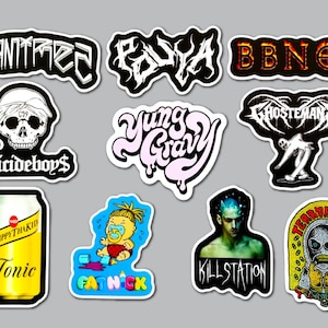 May include: A collection of stickers with various designs and text. The stickers include text such as "MONTREZ", "POLY", "BBNOS", "Suicideboys$", "Yung Gravy", "Ghosteman", "Trippythakid Tonic", "Fat Nick", "Kill Station", and "Terror Reid".