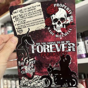 May include: A rectangular sticker with a dark red background, featuring a skull with roses, a motorcycle silhouette, and the text "Property of Kade Mitchell." Additional text includes relationship rules and the phrase "Are you going to be my Forever Reckless?"
