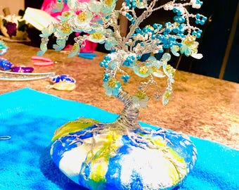 岩の上に置かれたワイヤー盆栽、青、白、緑