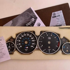 Puede incluir: Un nuevo cuadro de instrumentos BMW E39 con caras de fibra de carbono, velocímetros e indicadores. El velocímetro lee hasta 240 km/h. Incluye una nota de agradecimiento y documentos.