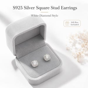 May include: S925 Silver Square Stud Earrings White Diamond Style. A pair of square-shaped silver stud earrings with a central stone surrounded by smaller stones, presented in a light gray velvet jewelry box with a gift box included label.