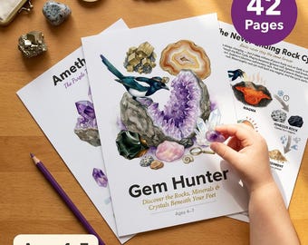 May include: A colorful educational book titled "Gem Hunter" with illustrations of rocks and crystals. The book has 42 pages and is designed for ages 4-7. A hand is holding a small purple crystal. A purple pencil is also visible.