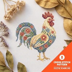 Può includere: Uno schema a punto croce raffigurante un gallo con corpo color crema, cresta e bargigli rossi e piume della coda blu. Il disegno è decorato con piccoli motivi floreali rosa e arancioni su tutto il piumaggio su un tessuto a griglia bianco.