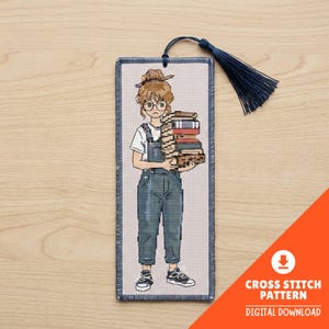 Peut inclure: Marque-page en point de croix avec une illustration de dessin animé d'une personne tenant une pile de livres. La personne porte des lunettes, une salopette et des baskets. Un gland bleu marine est suspendu en haut. Le texte "CROSS STITCH PATTERN DIGITAL DOWNLOAD" est en bas à droite.