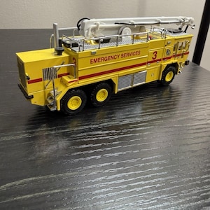 Peut inclure: Tasse en céramique blanche avec une anse noire, portant l'inscription "But First, Coffee" en noir. La tasse est présentée sur un fond flou, suggérant un cadre chaleureux.