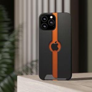 May include: Black and orange iPhone case with a central orange stripe. The case has a black Apple logo cutout and a textured black finish. The case is designed for protection.